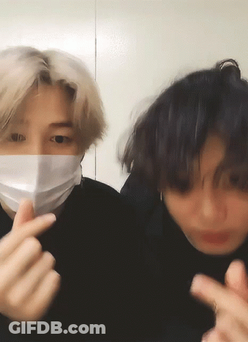 Man In Face Mask Making Heart With Fingers GIF