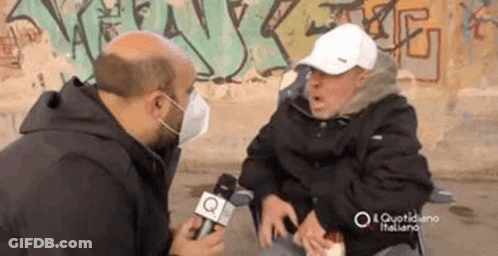 Man In Face Mask Talking To Man In Wheelchair GIF
