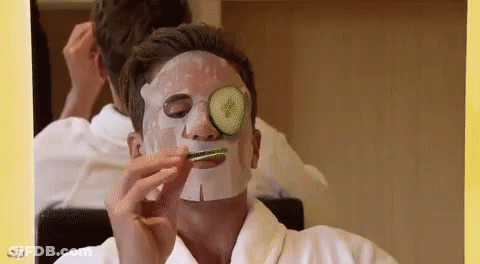 Man In Face Mask With Cucumber On Eye GIF
