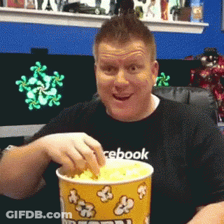 Man In Facebook Shirt Eating Popcorn GIF