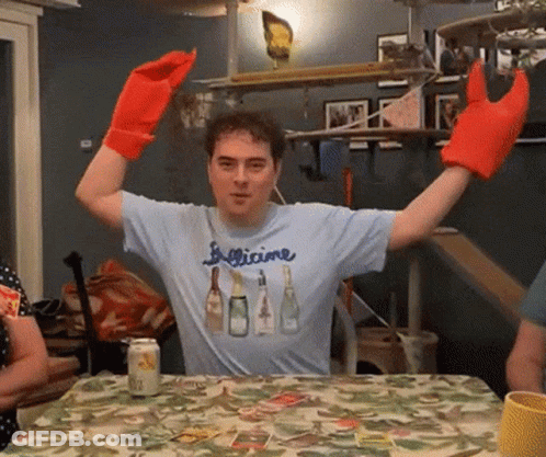 Man In Figlicine Shirt Sitting At Table GIF