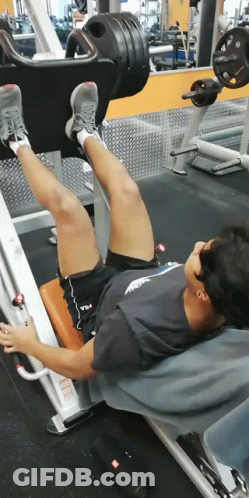 Man In Fila Shirt Doing Leg Presses GIF