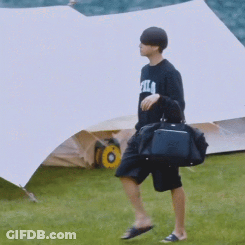 Man In Fila Shirt Walking With Duffel Bag GIF