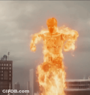 Man In Fire Suit Flying Over City Skyline GIF