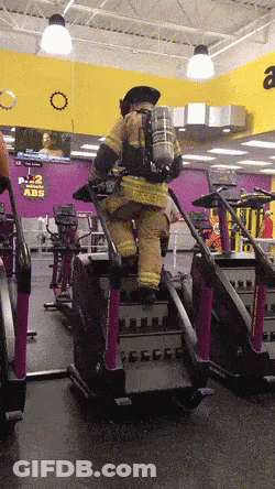 Man In Fireman Uniform Riding Treadmill At Gym GIF
