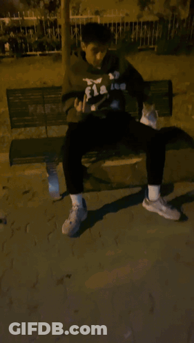 Man In Flakes Hoodie Sitting On Bench With Cat GIF