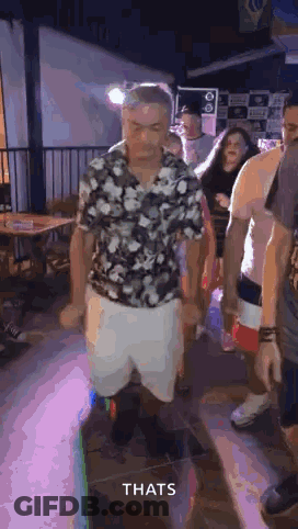 Man In Floral Shirt And White Shorts Dancing In Crowd GIF