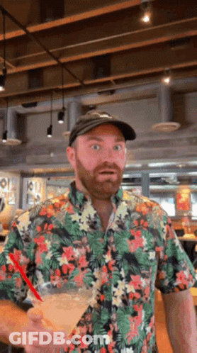 Man In Floral Shirt Holding Drink GIF
