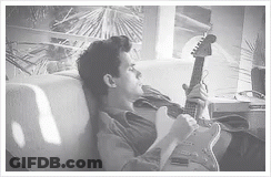 Man In Floral Shirt Holding Red Guitar GIF