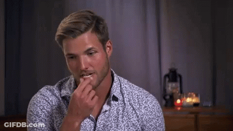 Man In Floral Shirt Sitting At Table With Candles GIF