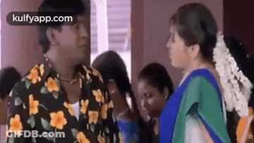 Man In Floral Shirt Talking To Woman In Blue Sari GIF