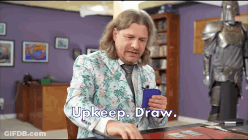 Man In Floral Suit Holding Blue Card Says Upkeep Draw GIF