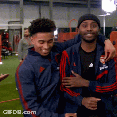 Man In Fly Emirates Jacket Hugging Another Man GIF