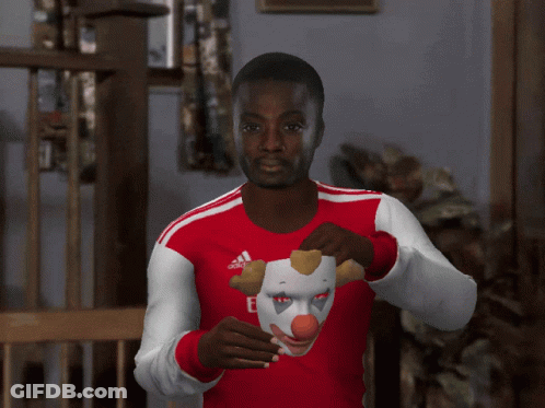 Man In Fly Emirates Jersey Holding Clown Mask Over Face GIF
