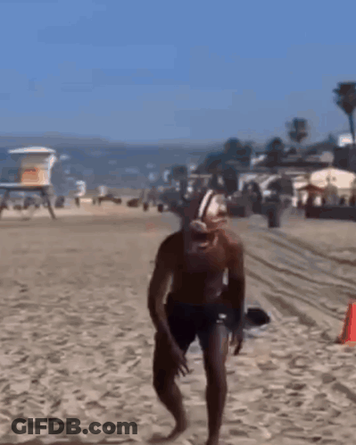 Man In Football Helmet Running On Beach GIF