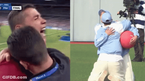 Man In France Lanyard Hugging Another On Soccer Field GIF