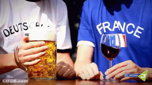 Man In France Shirt Holding Wine Next To Man In German Shirt GIF