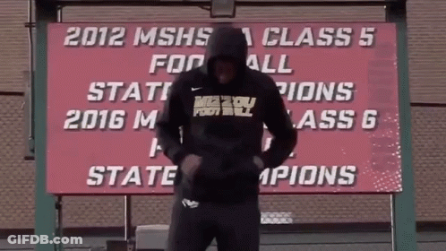 Man In Front Of 2012 MSHS Class 5 Football State Champions Sign GIF
