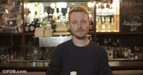 Man In Front Of Bar With Hansen Sign GIF