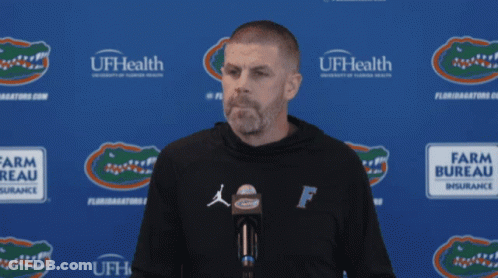 Man In Front Of Blue Wall Saying UFHealth GIF