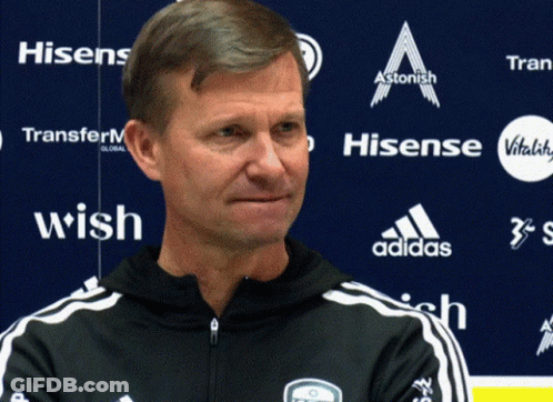 Man In Front Of Blue Wall With Hisense And Adidas Logos GIF