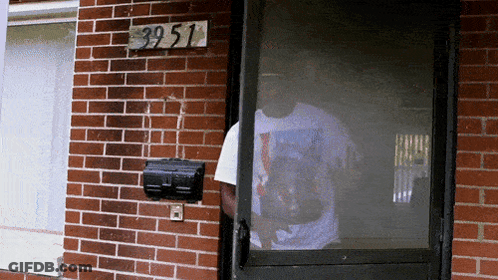 Man In Front Of Brick Building With Sign 39 51 GIF