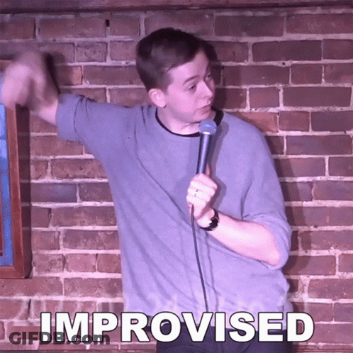 Man In Front Of Brick Wall Holding Microphone With Improvised GIF