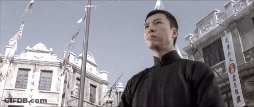 Man In Front Of Building With Chinese Writing GIF
