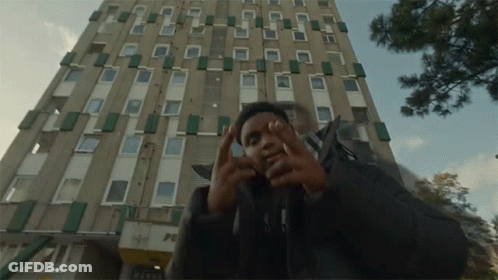 Man In Front Of Building With Peace GIF