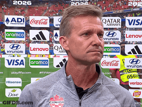 Man In Front Of Coca Cola And Visa Advertisements GIF