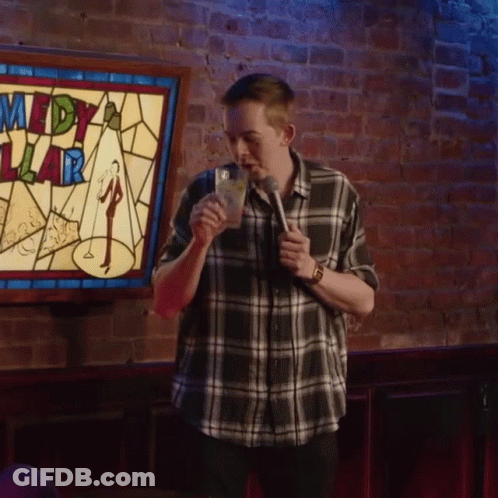 Man In Front Of Comedy Sign GIF