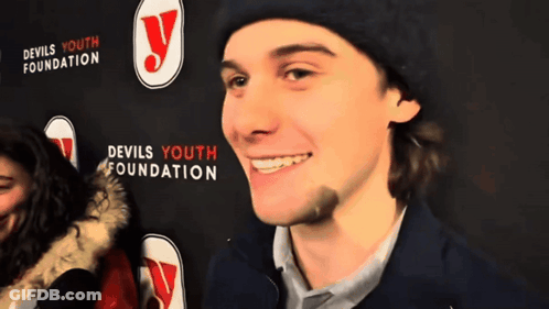 Man In Front Of Devils Youth Foundation Sign GIF