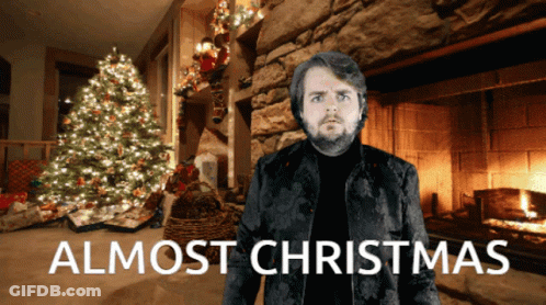 Man In Front Of Fireplace With Words Almost Christmas GIF