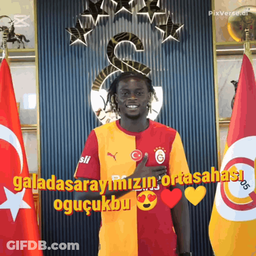 Man In Front Of Flags Saying Galatasarayimizin Ortasahasi GIF