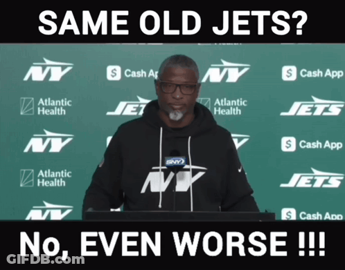 Man In Front Of Green Backdrop With NY Jets Logos GIF