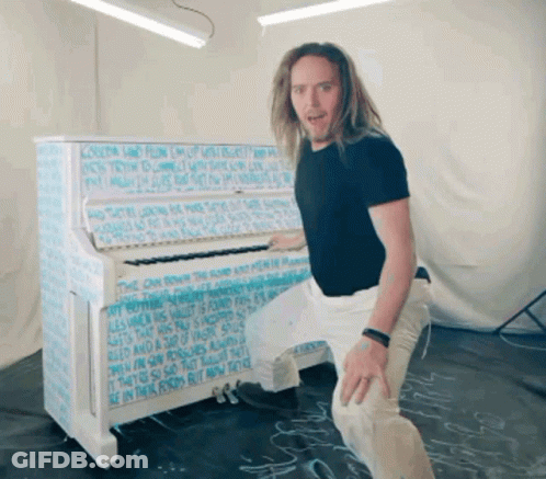 Man In Front Of Piano Covered In Writing GIF