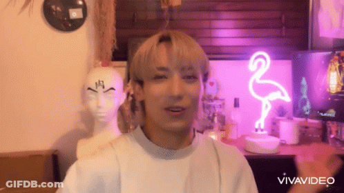 Man In Front Of Pink Flamingo Neon Sign And Mannequin Head GIF