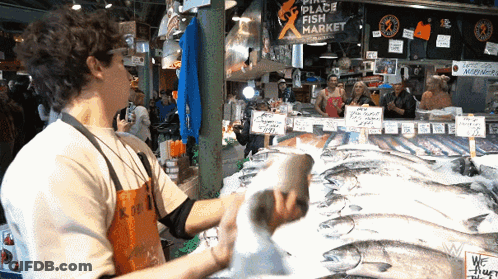 Man In Front Of Place Fish Market Sign GIF