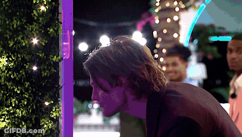 Man In Front Of Purple Light Looking Down GIF