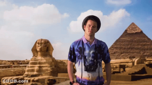 Man In Front Of Pyramid And Statue GIF