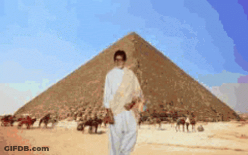 Man In Front Of Pyramid In Desert GIF