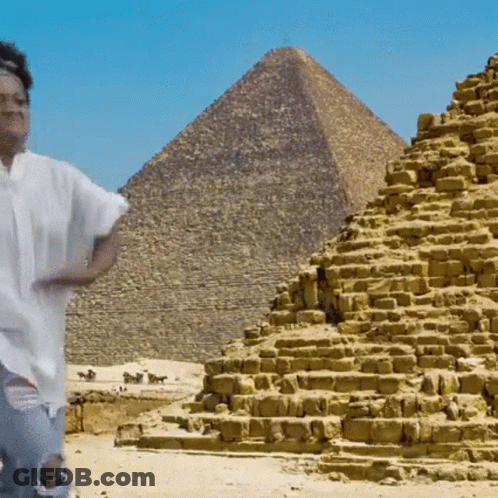 Man In Front Of Pyramid In Desert GIF