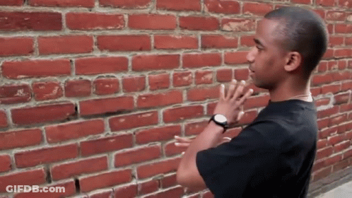 Man In Front Of Red Brick Wall GIF