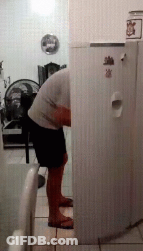 Man In Front Of Refrigerator With Strawberry Sticker GIF