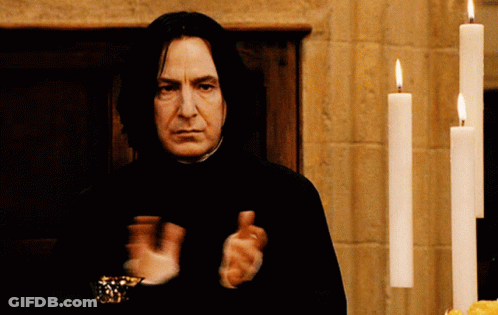 Man In Front Of Row Of Lit Candles GIF