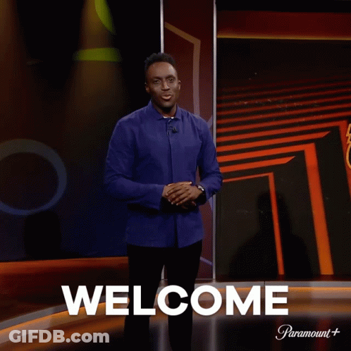 Man In Front Of Screen Saying Welcome GIF