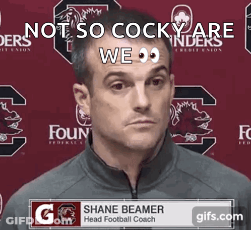 Man In Front Of Shane Beamer Banner GIF