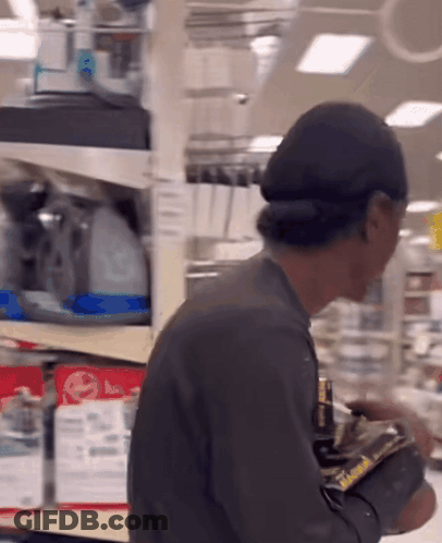 Man In Front Of Shelf With LG Sign GIF