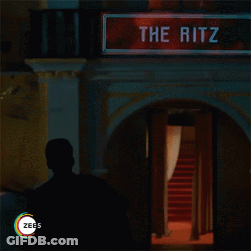 Man In Front Of Sign Reading The Ritz GIF