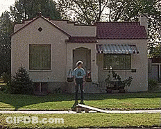 Man In Front Of Small House With Red Roof GIF